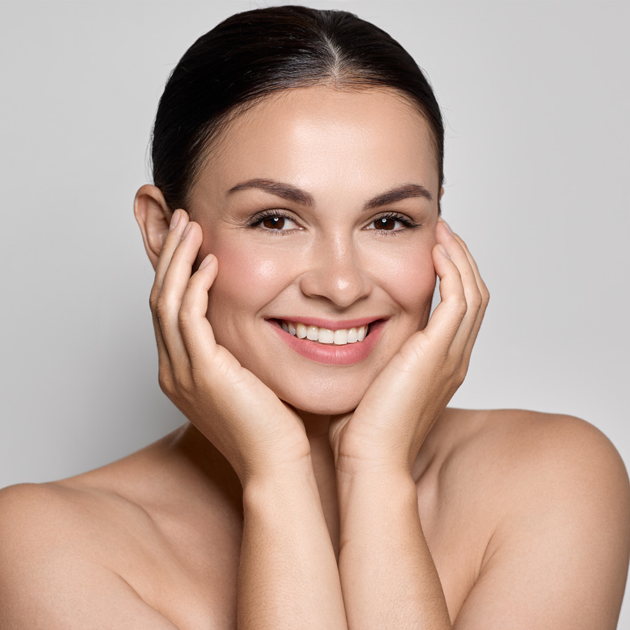 Woman with dark hair and glowing skin